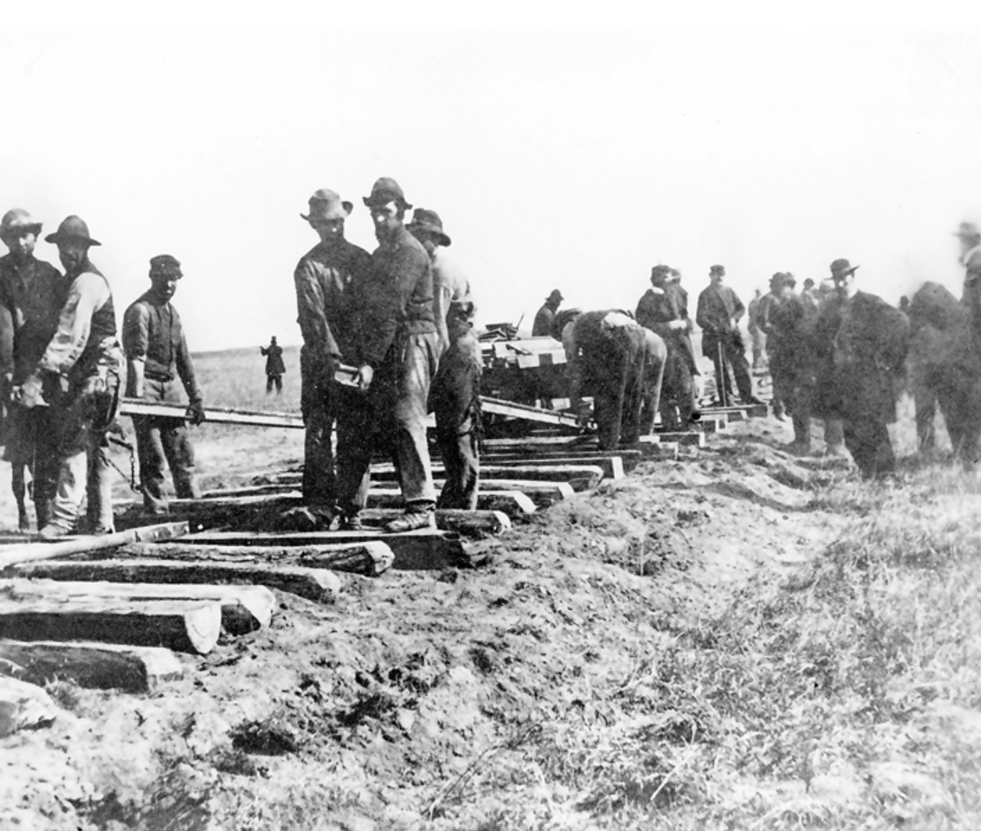 Railroad workers laying ties and rails by hand in Nebraska.